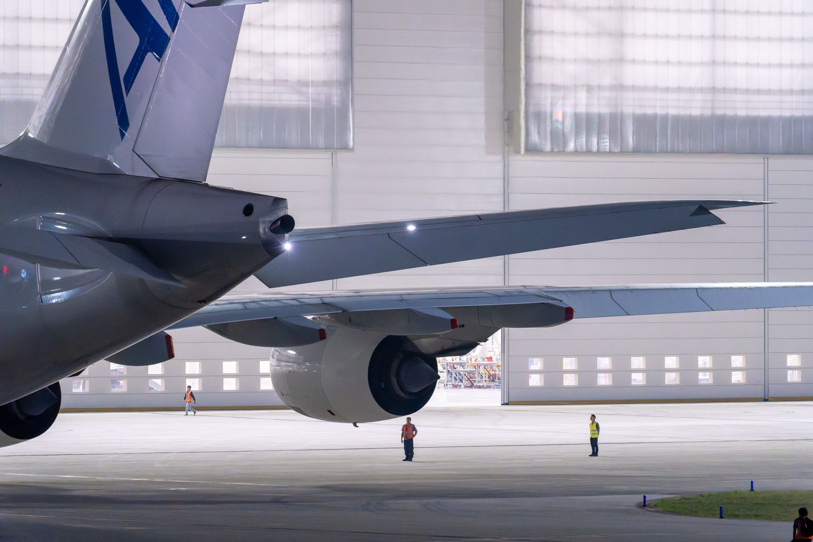 A commercial airliner inside an illuminated hangar