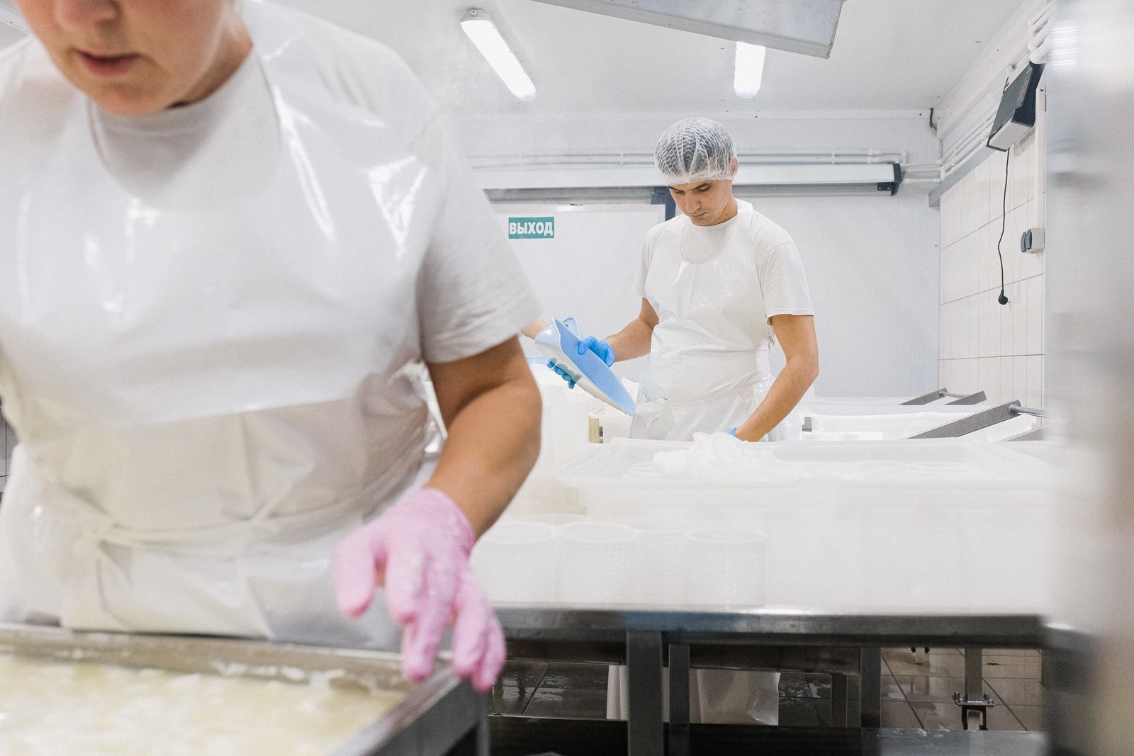 Workers in protective gear process dairy in a plant