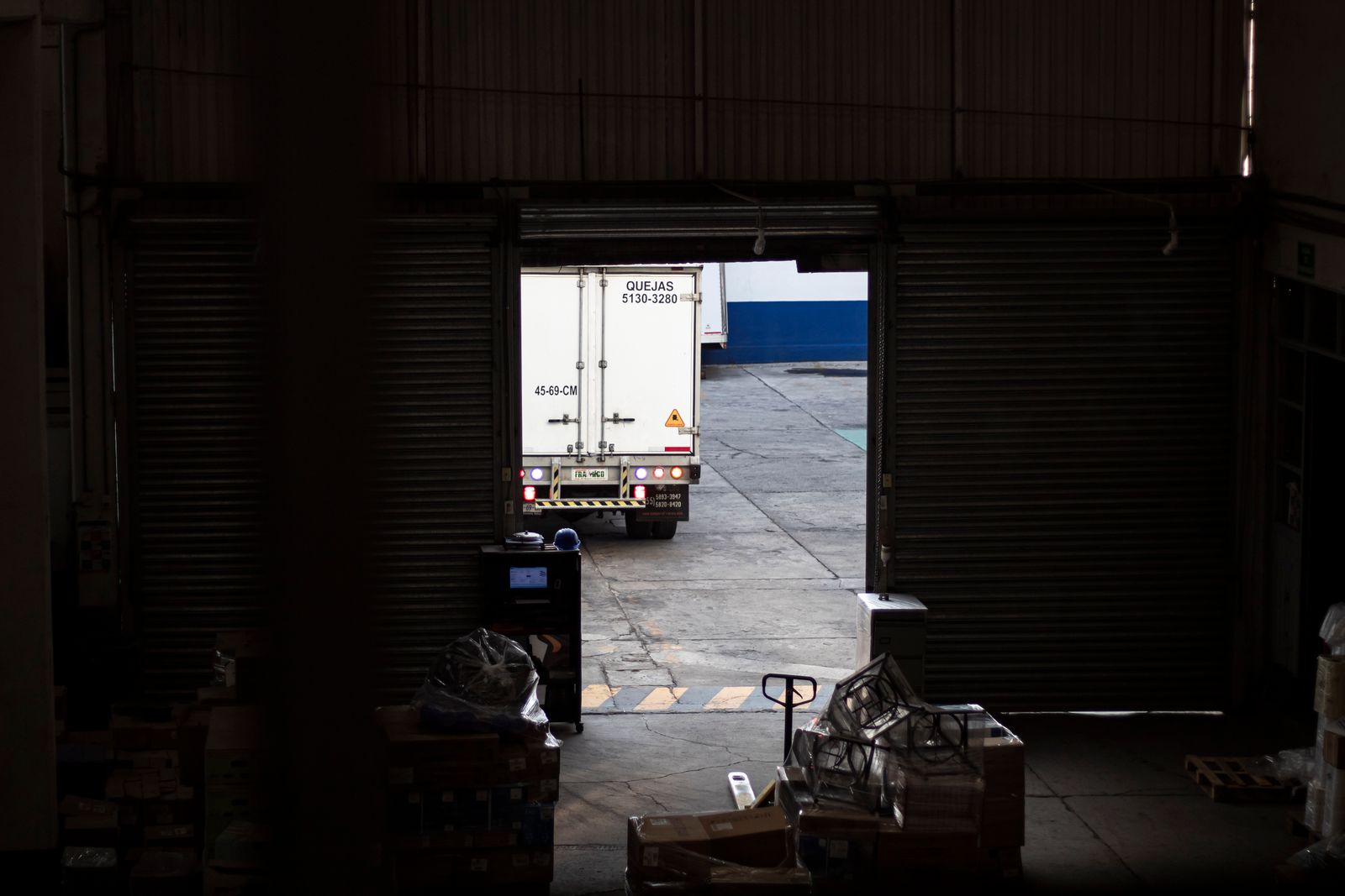 A delivery truck leaves a warehouse loading dock