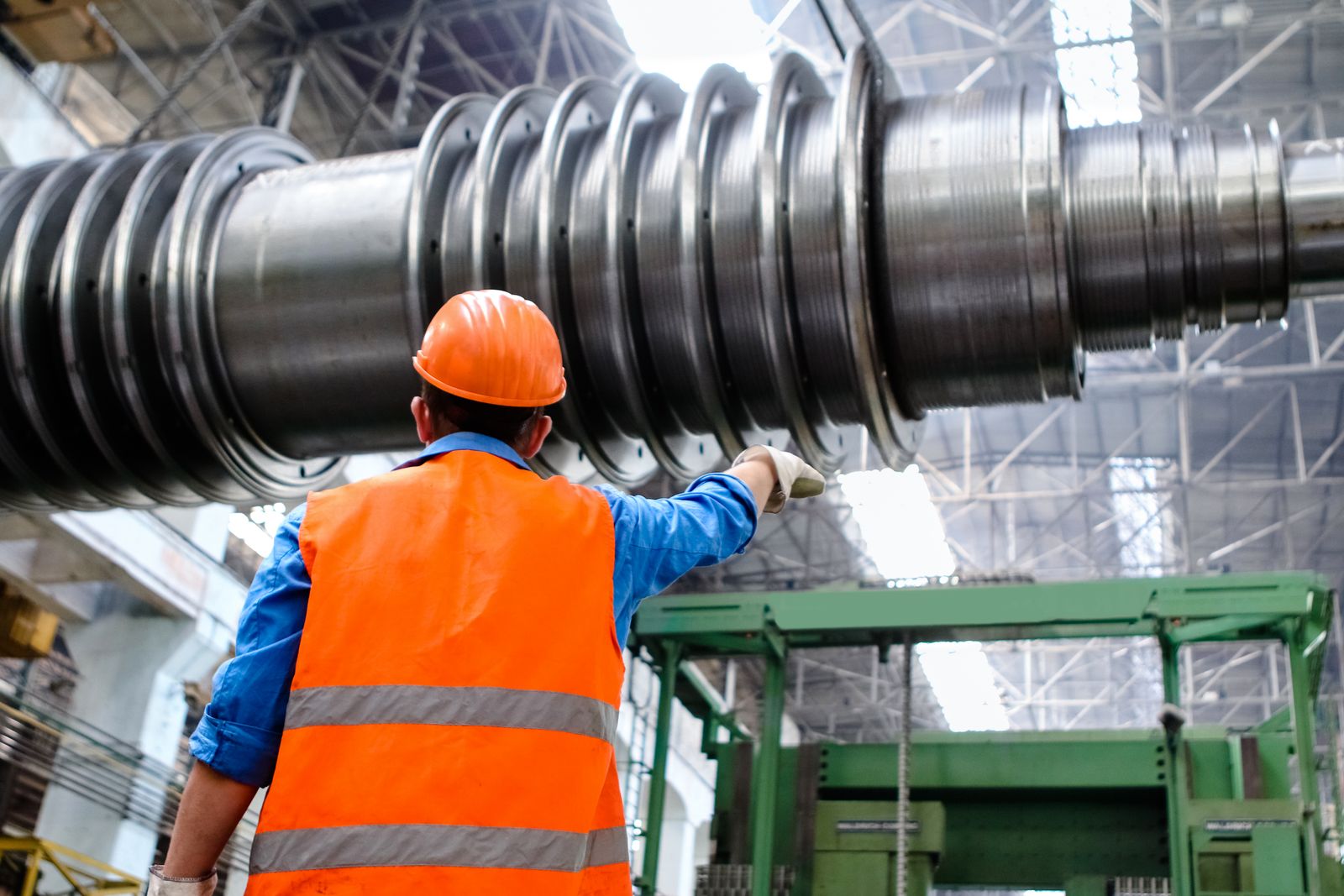 An engineer in hi vis and hard hat inspects equipment