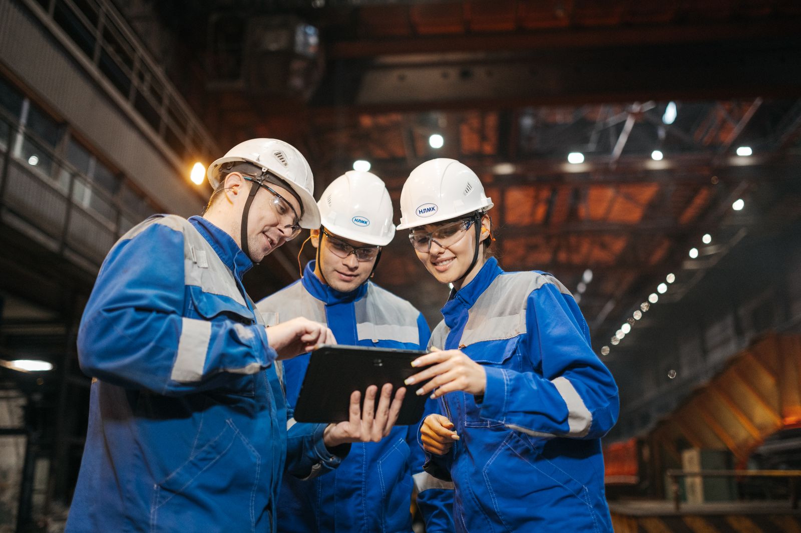 Engineers reviewing a project on a tablet on a plant floor