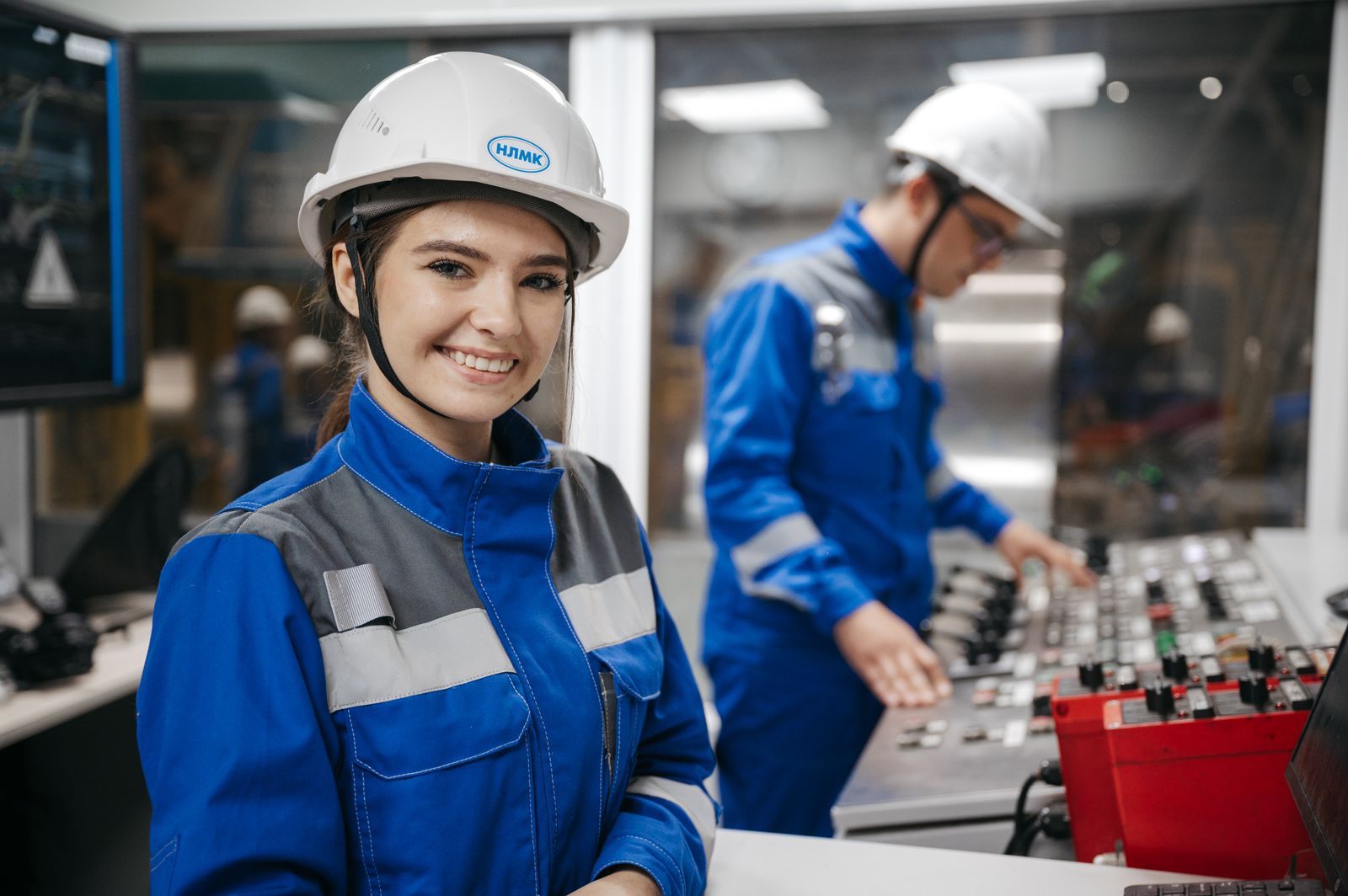 An engineer smiles in an industrial control room