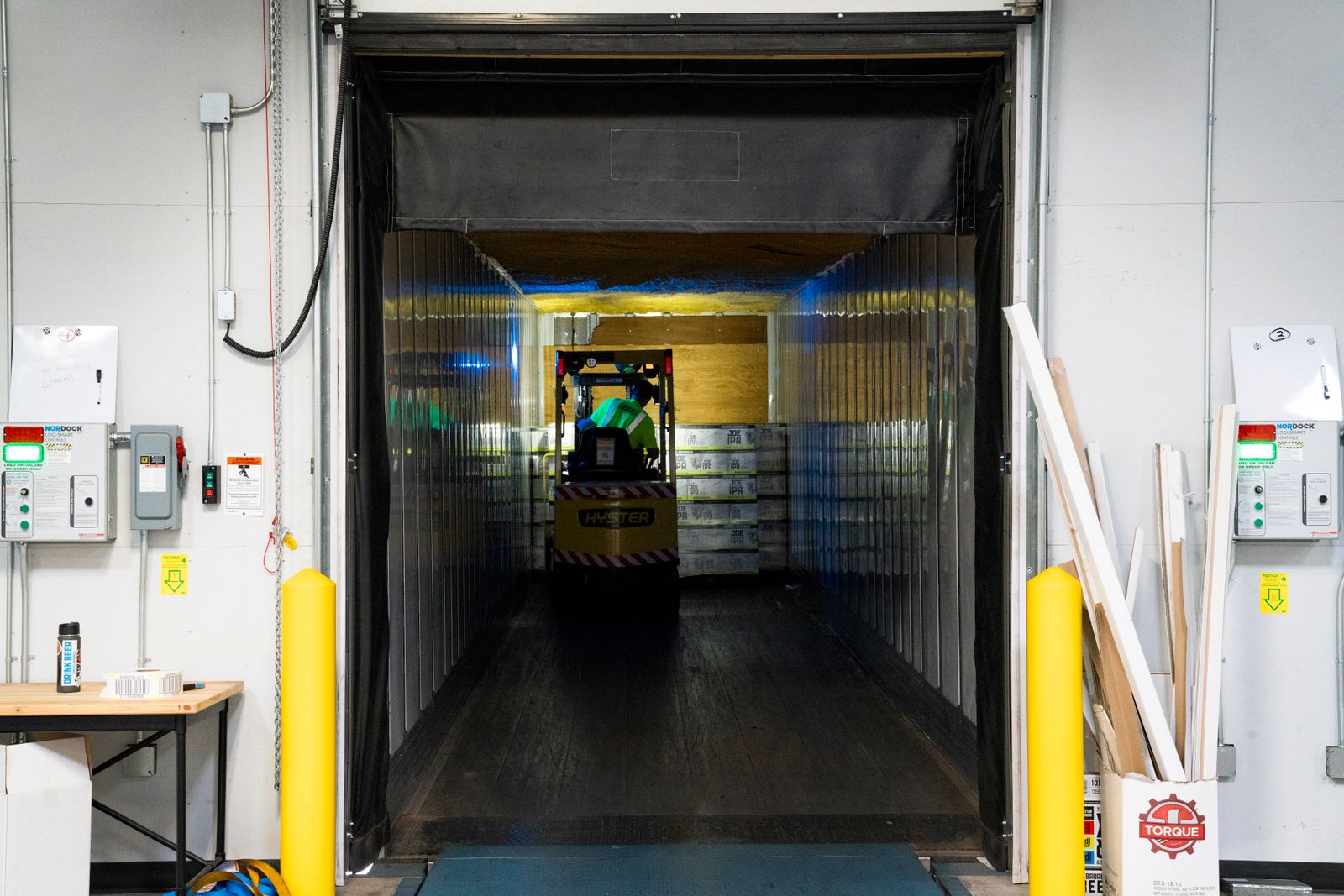 A forklift unloads goods at a warehouse loading dock