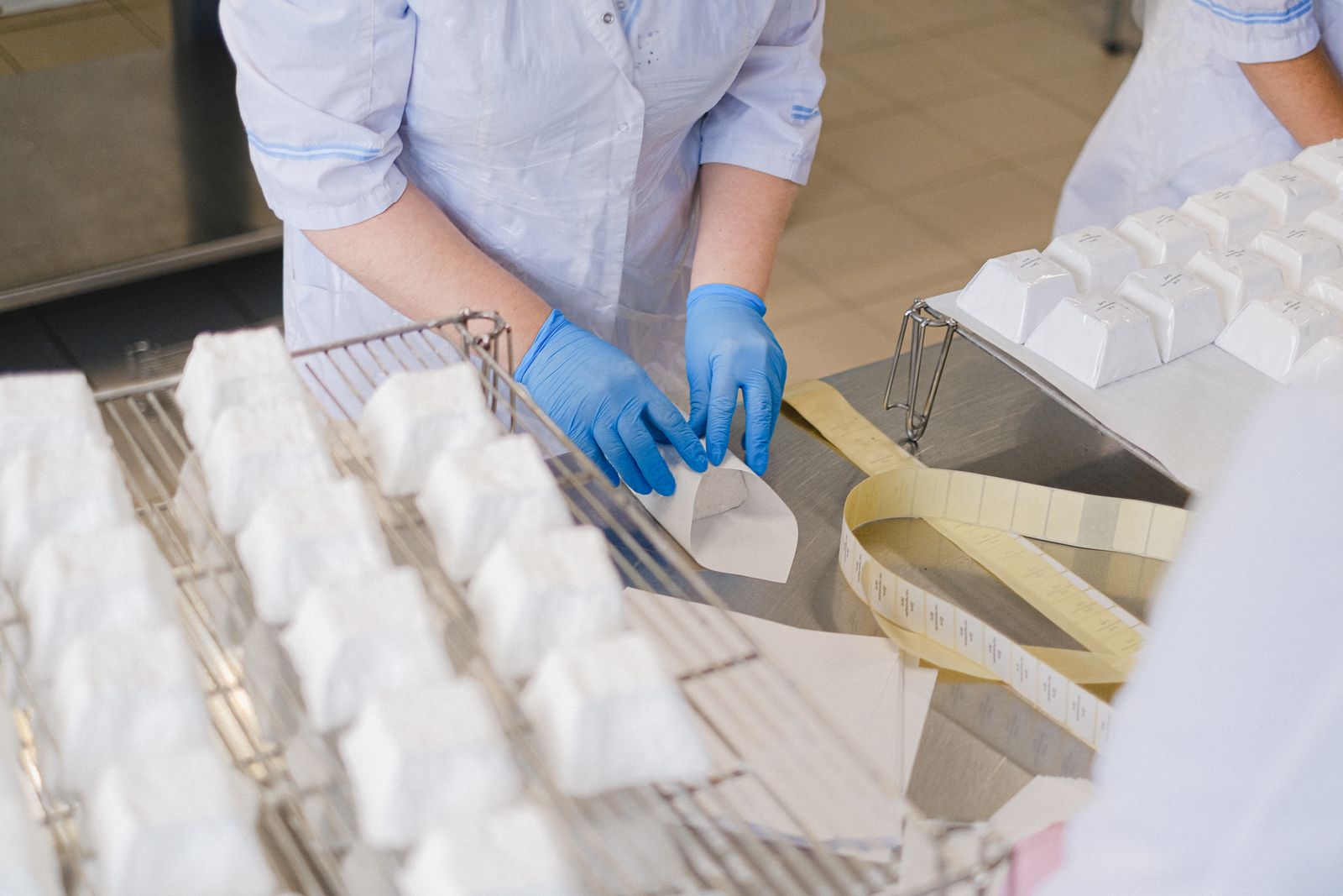 Gloved hands wrap product on a food line