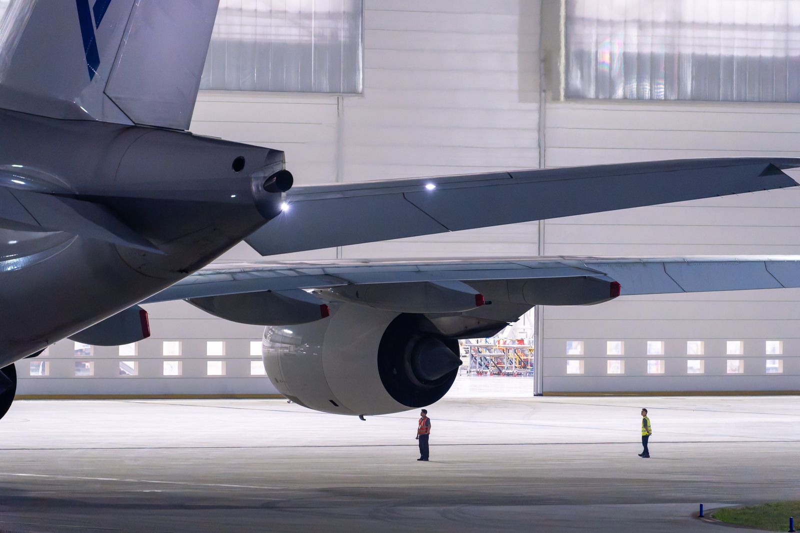 A maintenance crew inspects an airplane in a hangar