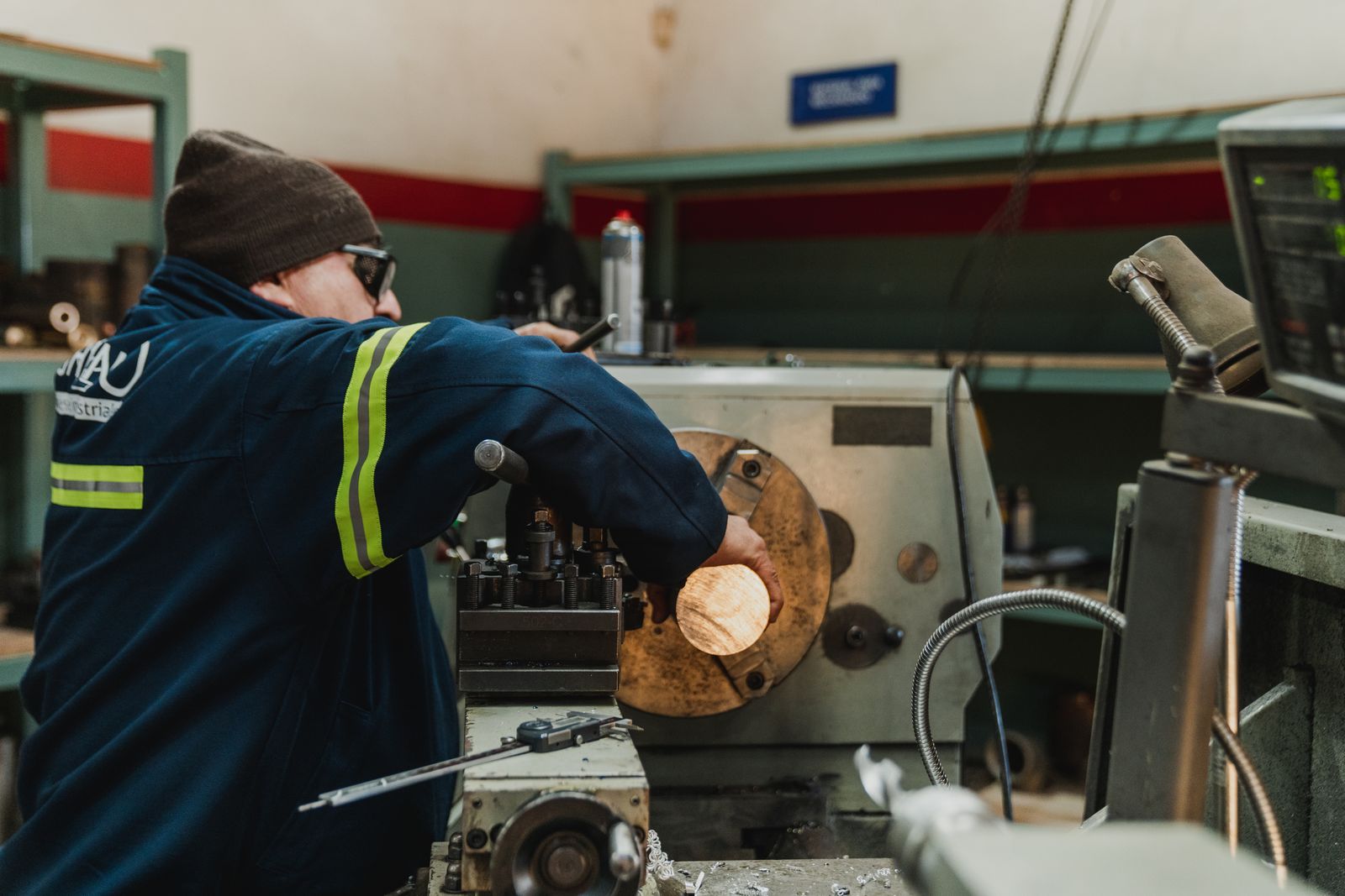 An industrial worker operates a lathe