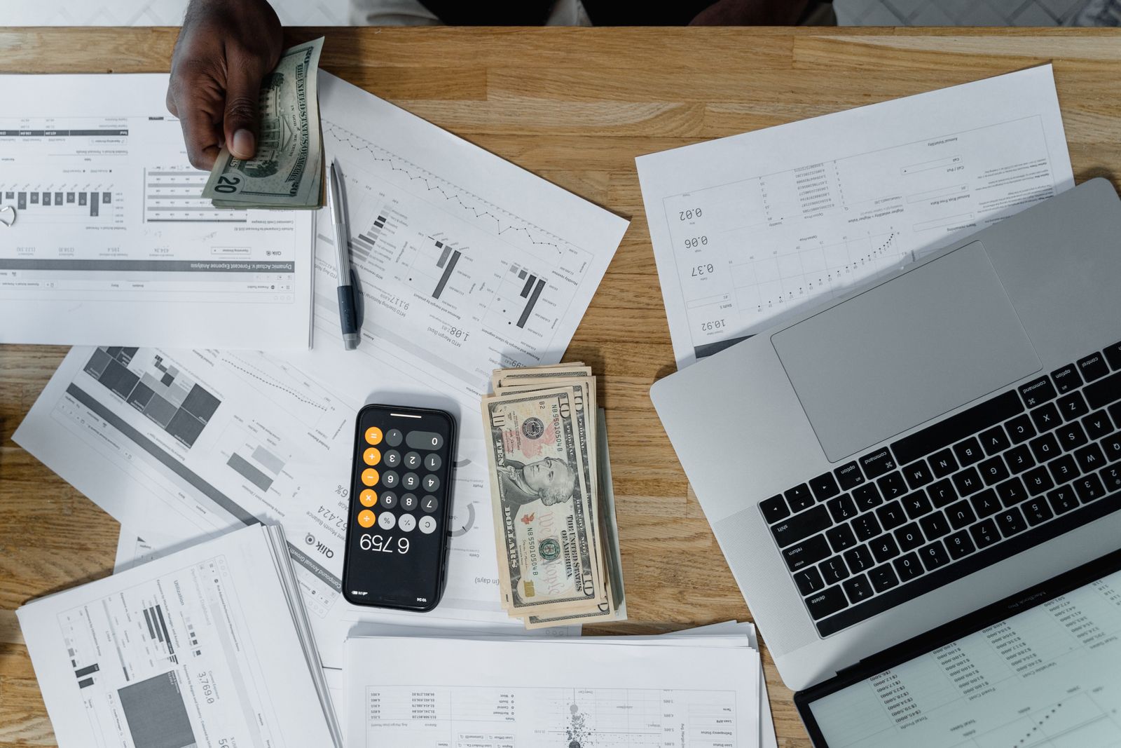 Overhead view of a desk with cash and payroll paperwork