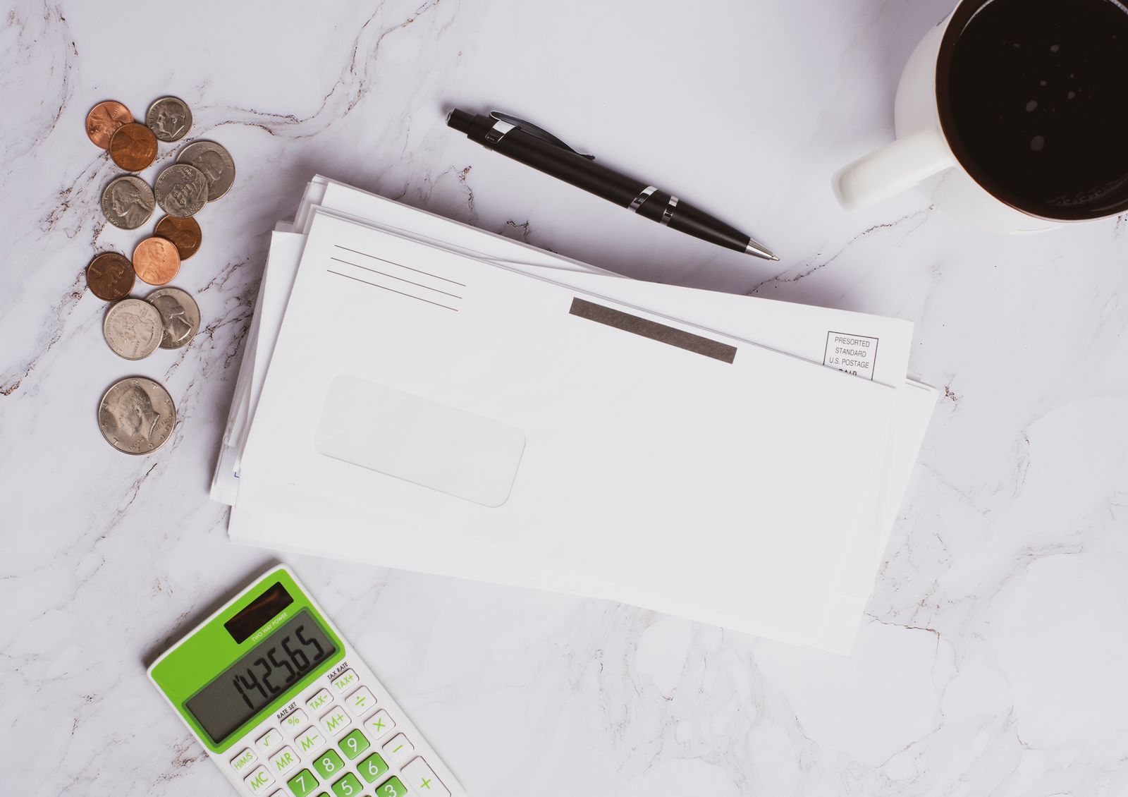 Financial documents, a calculator and coins on a desk