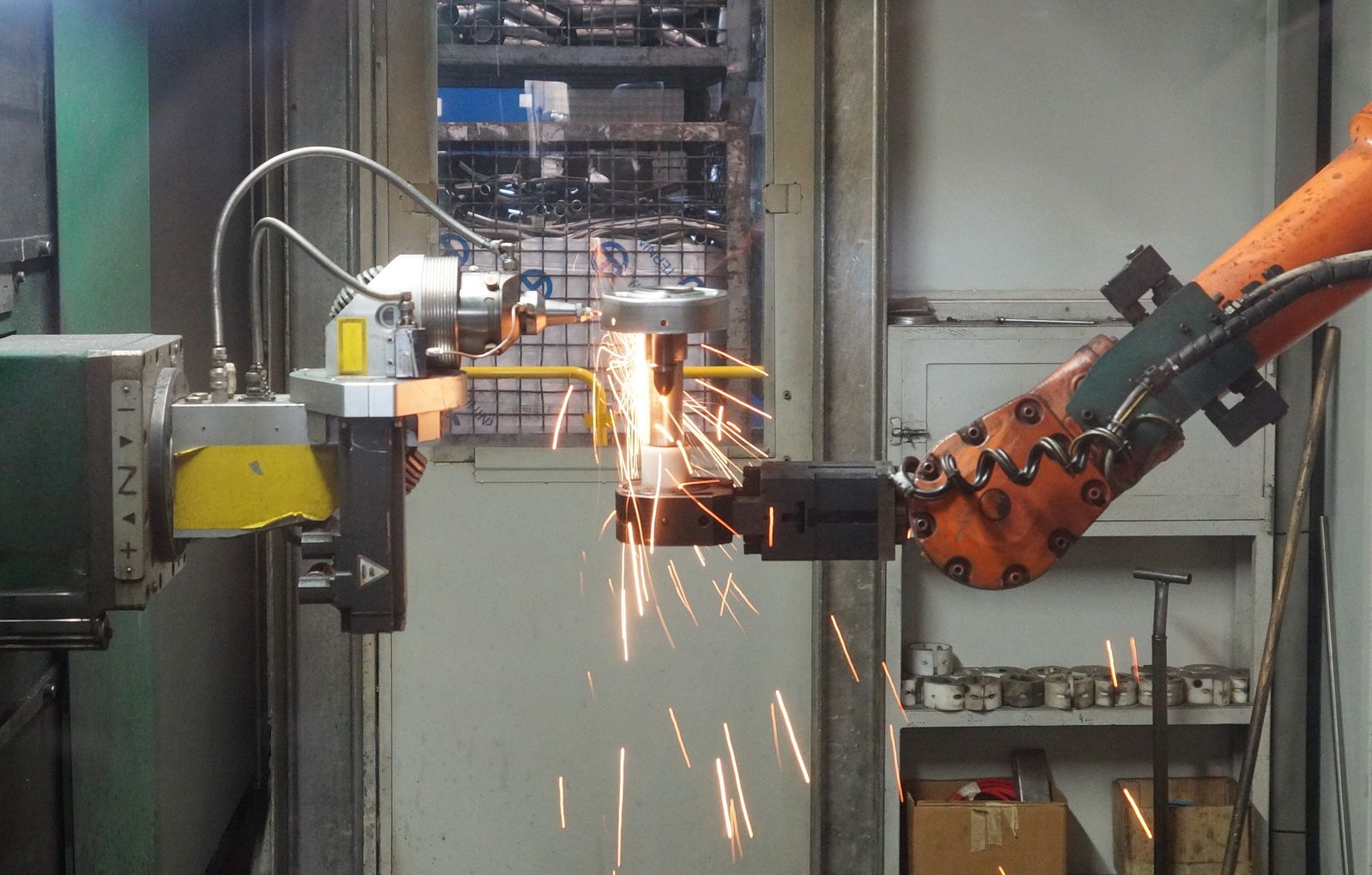 A robotic arm welds with bright sparks
