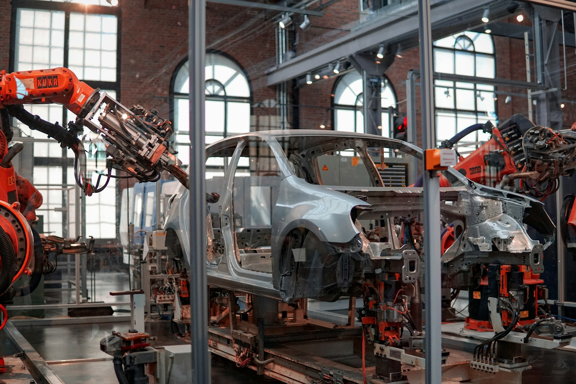 Orange robotic arms weld a car body on an automotive assembly line