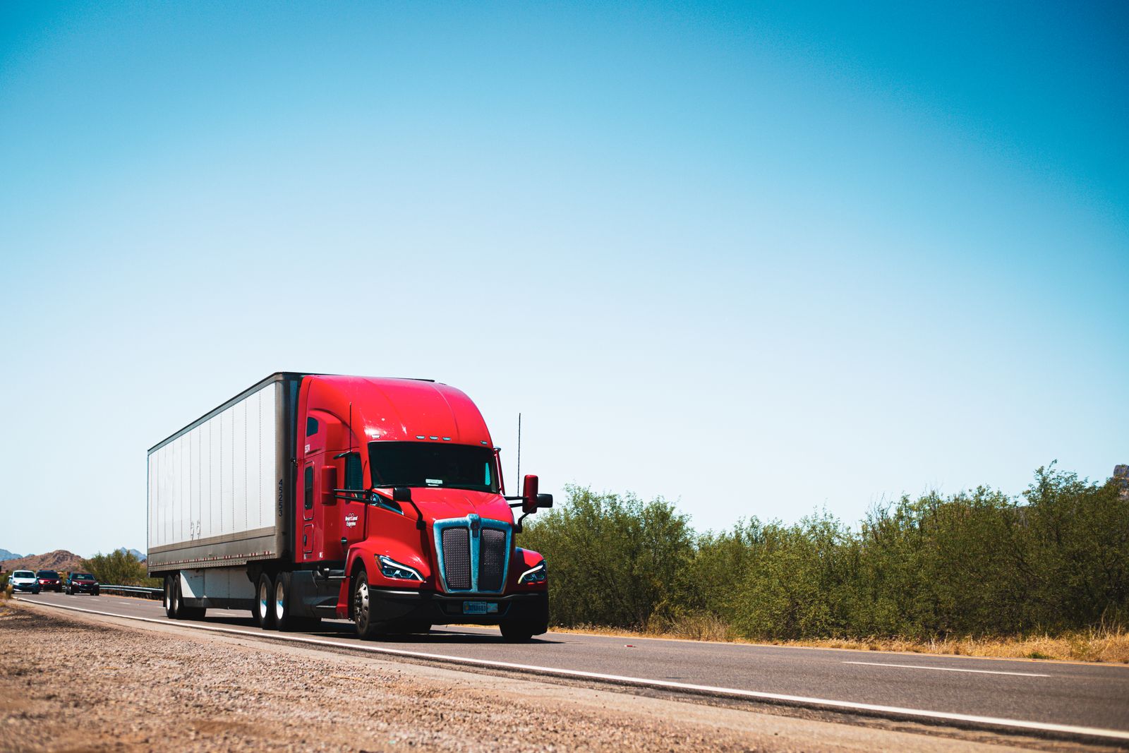 A red semi truck on an open highway