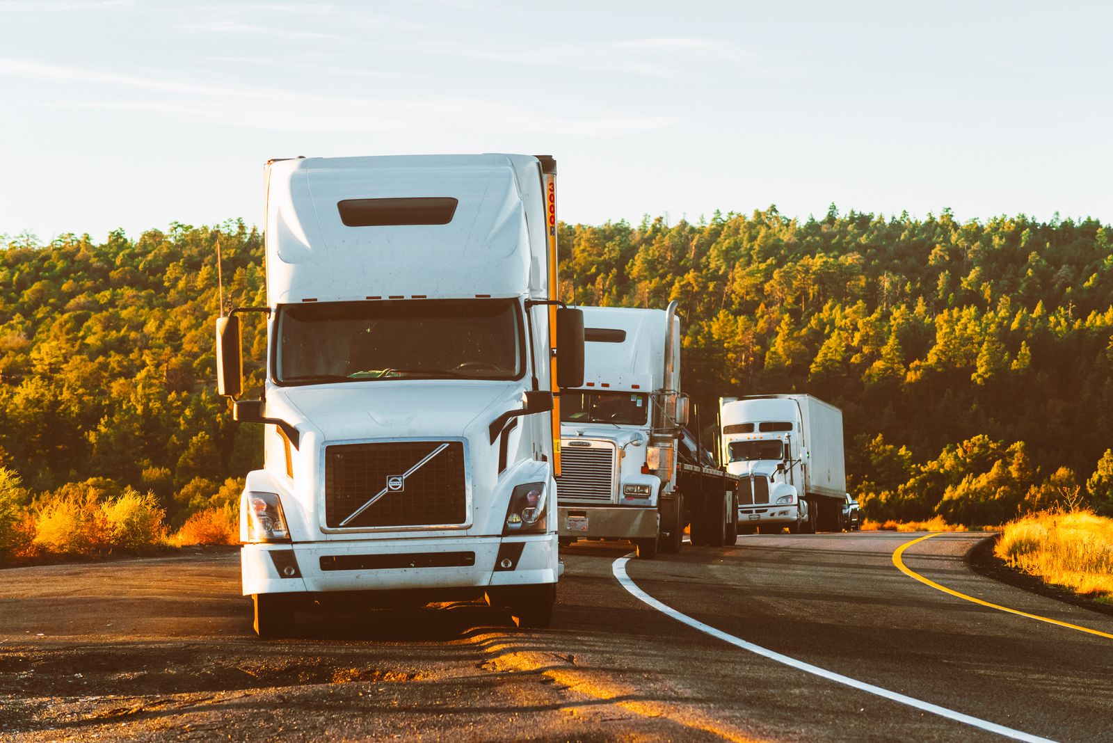 Three semi trucks on a highway