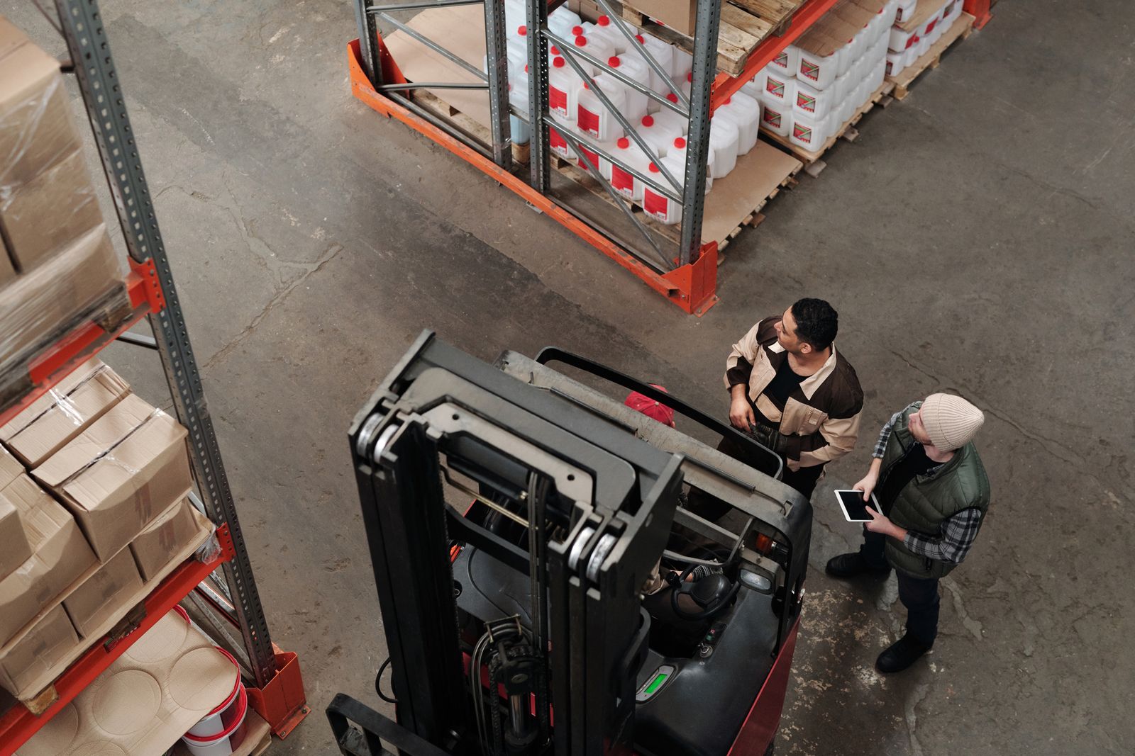 Two workers beside a forklift, seen from above