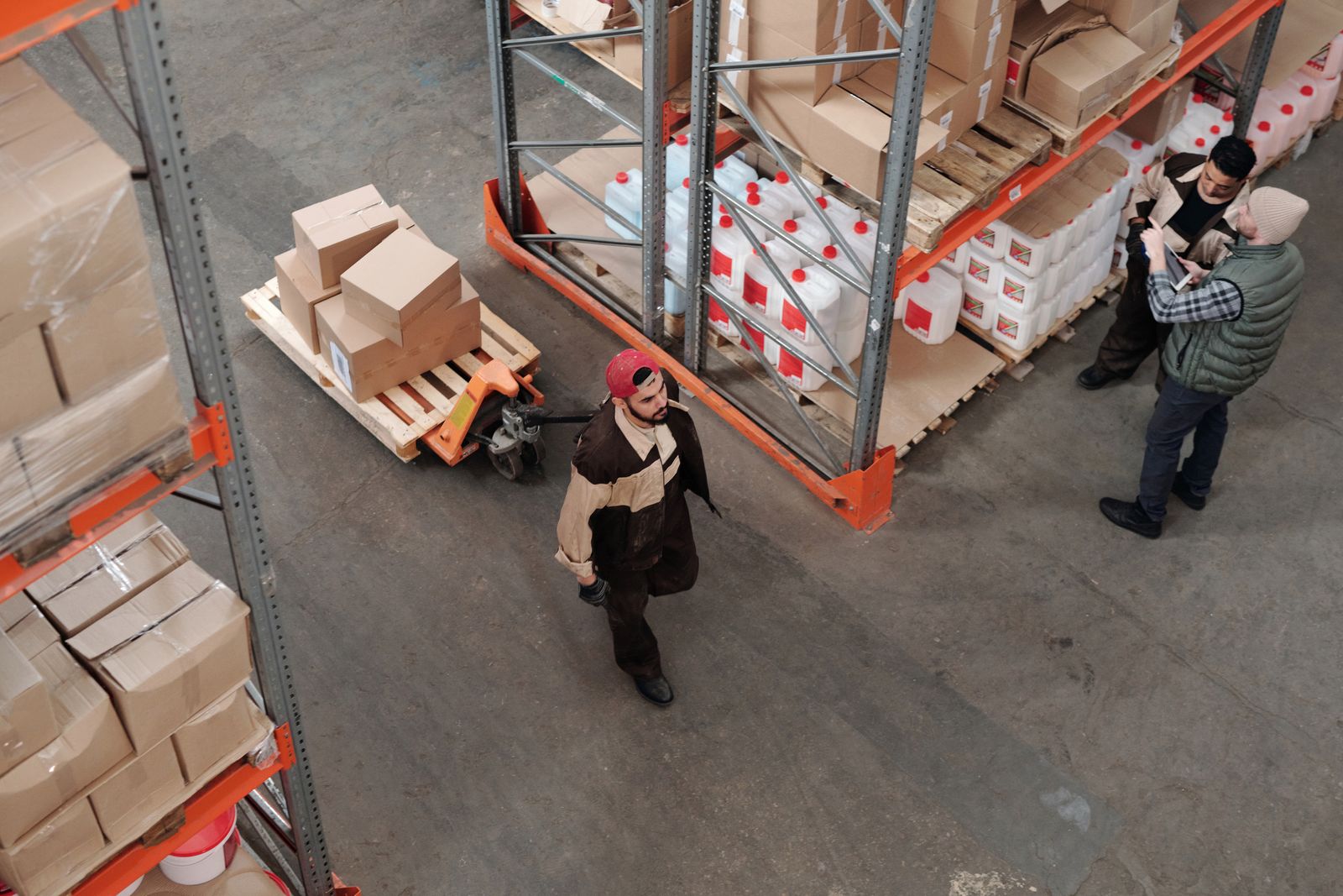 A team organizes inventory on pallets in a warehouse