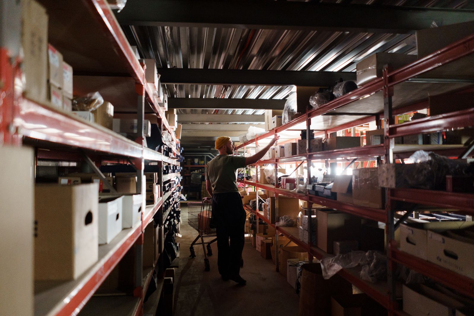 A warehouse worker arranges inventory on shelves