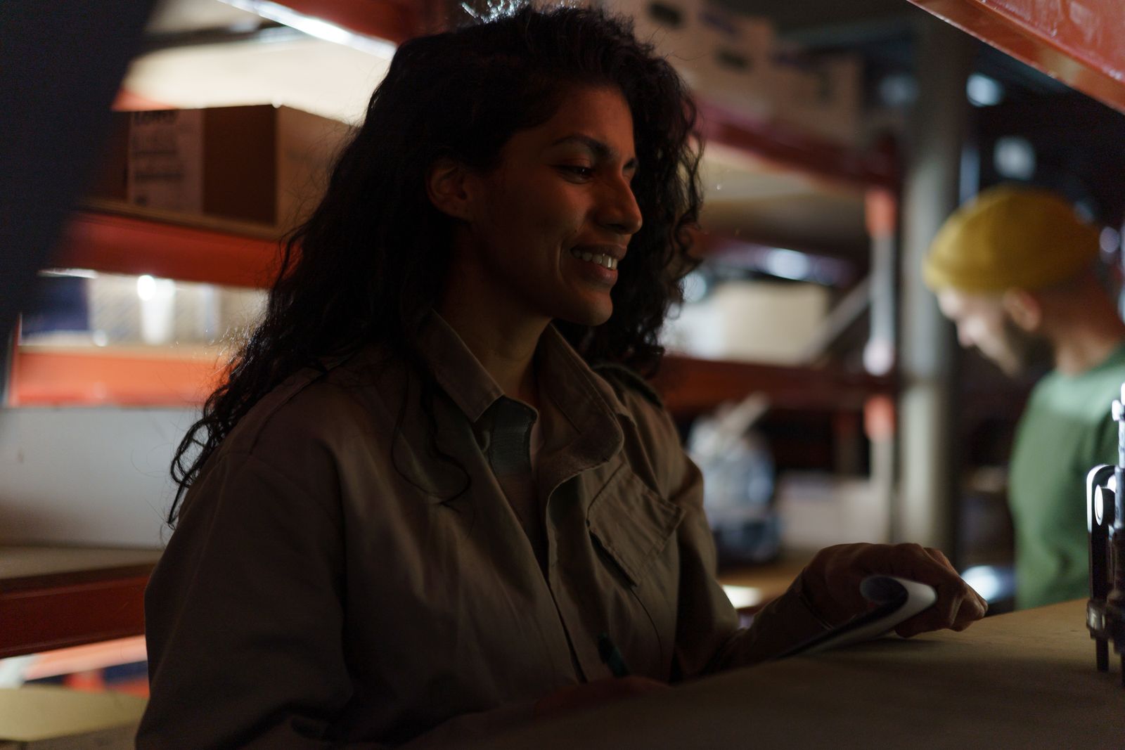 A smiling warehouse associate checks inventory