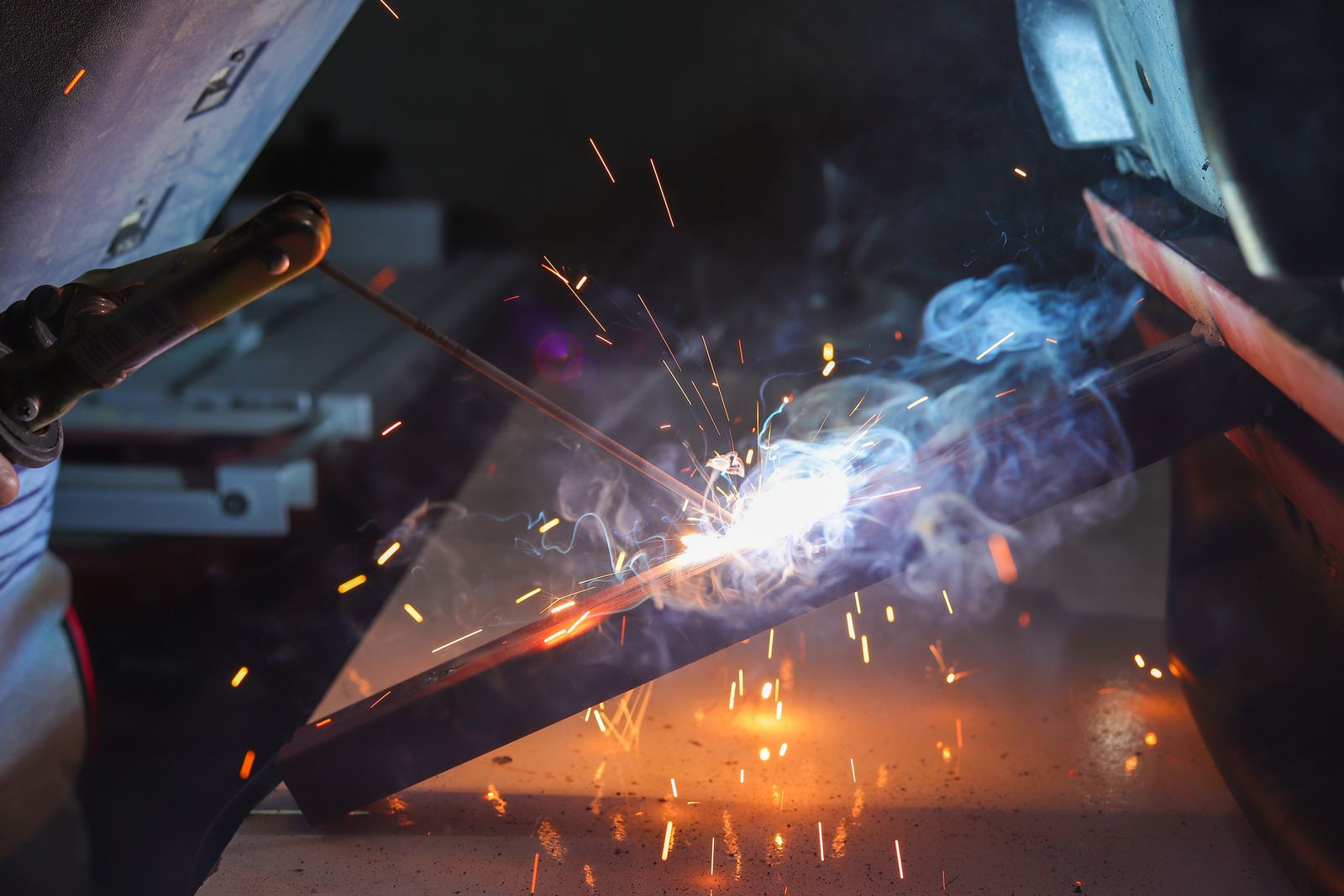 A welder at work with sparks and smoke