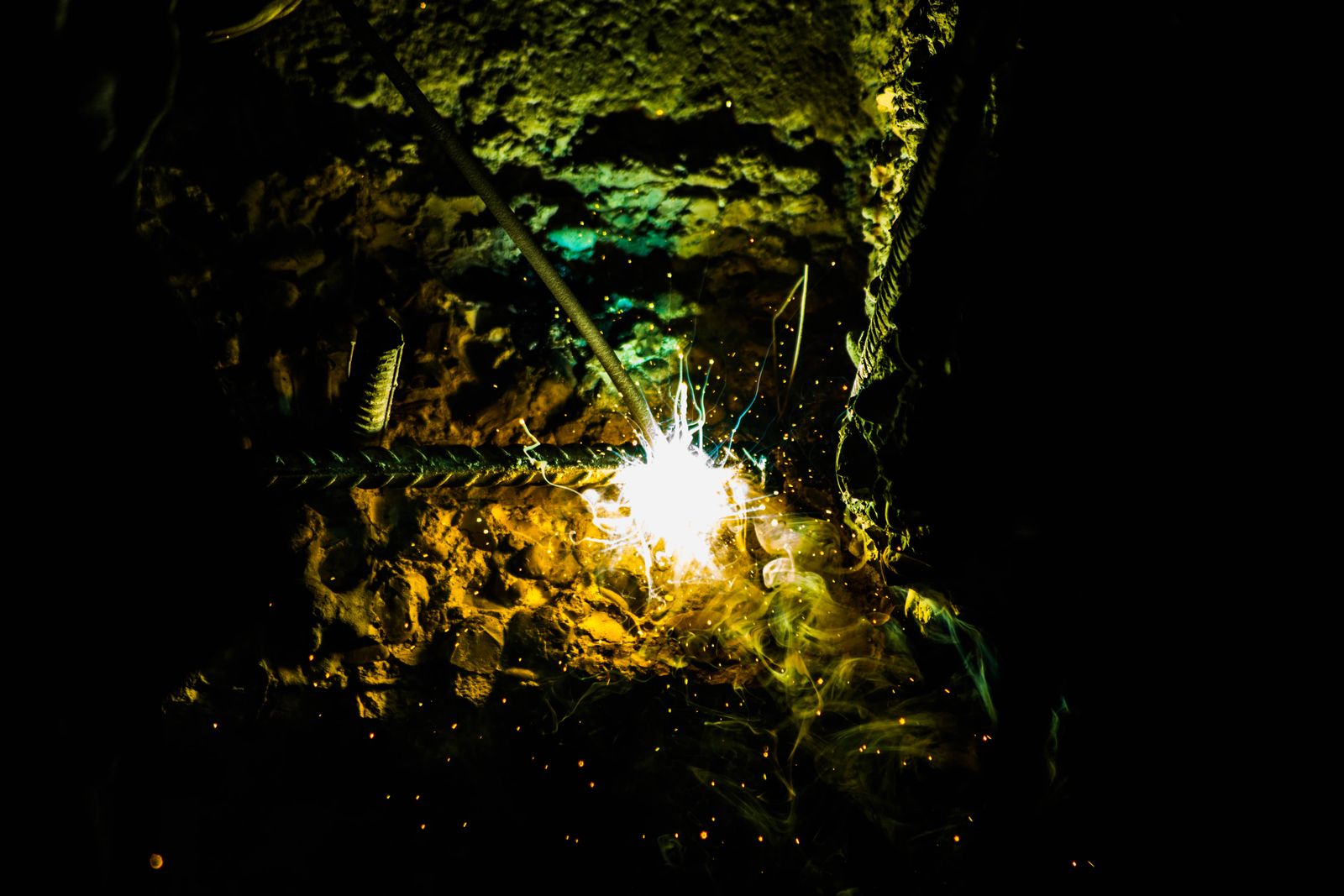 Welding sparks light up a dark fabrication shop