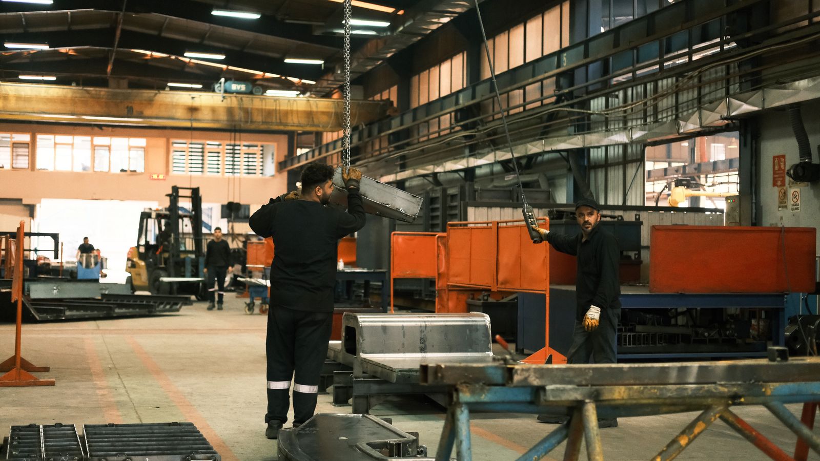 Workers operate machinery in a manufacturing plant